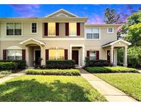 Charming townhome with manicured lawn and colorful shutters under a vibrant sky at 15825 Fishhawk View Dr, Lithia, FL 33547