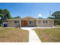 Charming single-story home with stone accents, and a welcoming walkway leading to the front door at 208 Ne Lincoln N Cir, St Petersburg, FL 33702