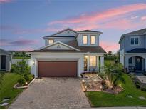 Beautiful two-story home featuring a brick paved driveway and a well-manicured lawn at 34135 White Fountain Ct, Wesley Chapel, FL 33545