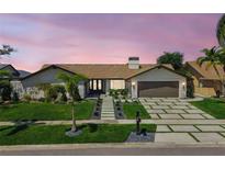 Charming single-story home featuring a manicured lawn, stone accents, and a modern driveway with integrated greenery at 4204 Saltwater Blvd, Tampa, FL 33615