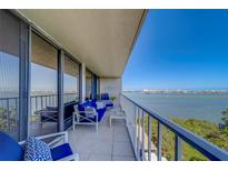 Inviting condo balcony showcasing serene water views and comfortable seating with nautical decor under a clear blue sky at 500 N Osceola Ave # 609, Clearwater, FL 33755