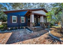 Charming home with brick pathway, covered porch, and beautiful blue exterior at 525 Lexington St, Dunedin, FL 34698