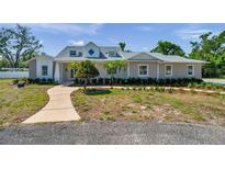 Charming home featuring a landscaped front yard, curved walkway, and a light gray exterior paint at 806 Linwood Ter, Lutz, FL 33549