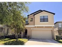 Inviting two-story home featuring a neutral color palette, attached two-car garage, and well-maintained landscaping at 12717 Lemon Pepper Dr, Riverview, FL 33578