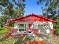 Charming single-story home with a red roof, brick accents, an attached garage, and well-maintained landscaping at 1444 Oak Haven Dr, Safety Harbor, FL 34695