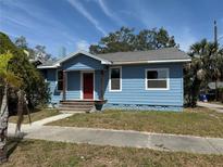 Charming blue single-story home with a bright red front door and well-maintained landscaping at 217 38Th N St, St Petersburg, FL 33713