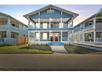Charming blue two-story home featuring double porches, white columns, and lush green lawn at 307 S Newport Ave, Tampa, FL 33606