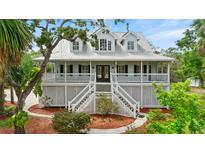 Charming two-story home featuring a spacious porch, double staircase and a lush, landscaped front yard at 380 Wellington Ave, Oldsmar, FL 34677