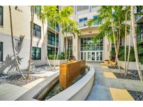 Modern building entrance featuring palm trees, a water feature, and glass doors at 400 4Th S Ave # 401, St Petersburg, FL 33701