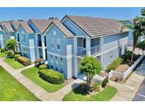 View of a stylish, two-story home featuring a balcony and well-maintained landscaping at 4002 Carrollwood Palm Ct, Tampa, FL 33624