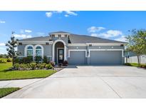 Stunning single-Gathering home featuring a two-car garage, well-maintained landscaping and a beautiful gray exterior at 5409 Del Coronado Dr, Apollo Beach, FL 33572
