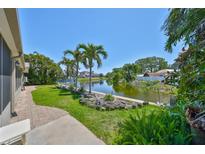 Spacious backyard with lush greenery and a beautiful pond view, enhancing the outdoor living experience at 5785 Bay Pines Lakes Blvd, St Petersburg, FL 33708