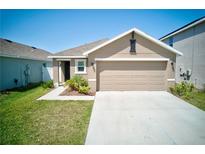 Charming single-Gathering home featuring a two-car garage and manicured front lawn at 588 Olive Conch St, Ruskin, FL 33570