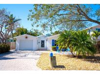 Charming one-story home featuring a sunny front yard, paver driveway, and attached garage at 1208 Bay Pine Blvd, Indian Rocks Beach, FL 33785