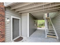 Condo entrance with gray door, gray siding, and white trim; exterior staircase to units above at 1400 Gandy N Blvd # 1701, St Petersburg, FL 33702