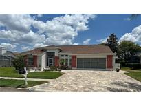 Charming single-story home with a brick-accented facade, well-manicured lawn, and a paved driveway at 14334 Teasdale Ave, Hudson, FL 34667