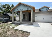 New construction home with a concrete driveway and covered porch at 1828 27Th N Ave, St Petersburg, FL 33713
