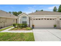 Charming single-story home with a well-manicured lawn and attached two-car garage at 19232 Barred Owl Ct, Land O Lakes, FL 34638