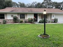 Charming single-story home with a well-maintained lawn, complemented by a classic exterior lighting fixture at 1991 63Rd N Ave, St Petersburg, FL 33702