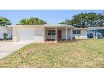 Charming one-story home featuring a brick facade and a well-maintained lawn at 2551 Fentress Pl, Holiday, FL 34691