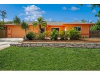 Charming single-story home with vibrant landscaping and a well-manicured lawn at 413 Blackburn Rd, Nokomis, FL 34275
