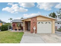 Charming single-Gathering home with a brick facade, well-maintained lawn, and attached garage at 4902 Blue Heron Dr, New Port Richey, FL 34652