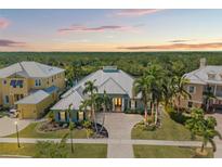 Stunning home with metal roof, lush landscaping, and a picturesque view of the surrounding natural environment at dusk at 819 Islebay Dr, Apollo Beach, FL 33572