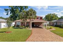 Charming single-story brick home with a covered carport and a well-manicured lawn and landscape at 3309 W Ellicott St, Tampa, FL 33614