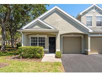 Charming single-story home with well-maintained landscaping, attached garage, and neutral color palette on a sunny day at 3583 Wembley Way # 101, Palm Harbor, FL 34685