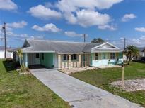 Charming single-story home with a long driveway, front yard, and unique architectural details at 703 Bel Air Ave, Sun City Center, FL 33573