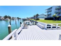Waterfront condo features a relaxing outdoor space with chairs, bench, and table overlooking the community canal at 719 Pinellas Bayway S # 309, Tierra Verde, FL 33715