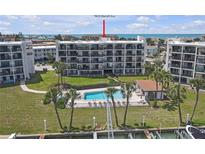 Beautiful view of the condo community featuring a pool, boat docks, and manicured green space at 9815 Harrell Ave # 502, Treasure Island, FL 33706