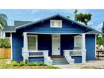 Charming blue home with white trim, front porch, and landscaped yard at 1002 E North Bay St, Tampa, FL 33603