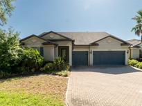 Charming single-story home with a two-car garage, paver driveway and lush landscaping in the front yard at 10404 Scarlet Chase Dr, Riverview, FL 33569