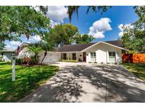 Charming single-story home featuring a well-manicured lawn, driveway, and attached two-car garage at 10609 Orange Grove Dr, Tampa, FL 33618