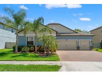 Charming single-story home with a well-manicured lawn, mature landscaping, and a three-car garage at 2835 Hilliard Dr, Wesley Chapel, FL 33543