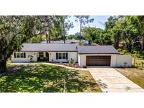 Charming single-story home featuring a neatly landscaped front yard and attached garage at 3225 Bea Ct, Land O Lakes, FL 34639