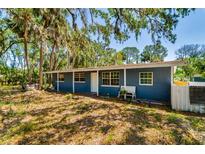 Charming single-story home featuring a front porch, mature trees, and a classic design at 3226 Palmetto Rd, Wimauma, FL 33598