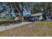 Charming single-story home with a long driveway and mature trees offering ample shade on a sunny day at 3721 140Th Ave, Largo, FL 33771