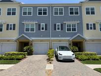 A well-maintained townhome featuring a brick driveway, attached garages, and manicured landscaping at 4053 Rocky Shores Dr, Tampa, FL 33634