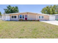 Charming single-story home features a well-manicured lawn and a vibrant red front door at 4732 W Wyoming Ave, Tampa, FL 33616