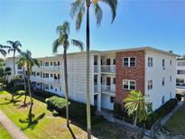 Condo building exterior featuring palm trees, a combination of brick and painted walls, and multi-level balconies at 5150 10Th N Ave # 310A, St Petersburg, FL 33710