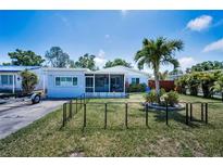 Charming single-story home featuring a well-maintained lawn, a screened porch, and a delightful palm tree at 5474 77Th N Ave, Pinellas Park, FL 33781