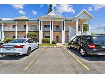 Exterior of a lovely two-story condominium complex with ample parking for residents and guests on a bright, sunny day at 2291 Americus W Blvd # 41, Clearwater, FL 33763