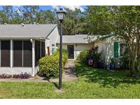 Inviting front entrance with a garden path, manicured lawn, and mature landscaping at 3204 40Th S Way # B, St Petersburg, FL 33711
