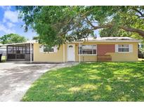 Charming single-story home with a large front yard, mature tree, and screened porch at 3214 W Rogers Ave, Tampa, FL 33611