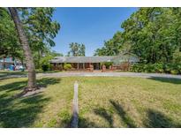Charming one-story brick home featuring a large front lawn with mature trees offering a park-like setting at 4315 W Azeele St, Tampa, FL 33609