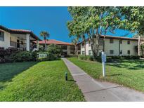 Well-maintained condo building with lush landscaping and a sidewalk leading to the entrance at 502 Hammock Pine Blvd # 502, Clearwater, FL 33761