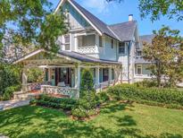 Inviting curb appeal with well-manicured lawn, lush landscaping, and a charming, light blue craftsman-style home at 712 S Newport Ave, Tampa, FL 33606