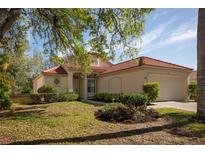 Charming single-story home featuring a red tile roof, well-maintained landscaping, and an attached two-car garage at 717 Lighthouse Dr, Tarpon Springs, FL 34689